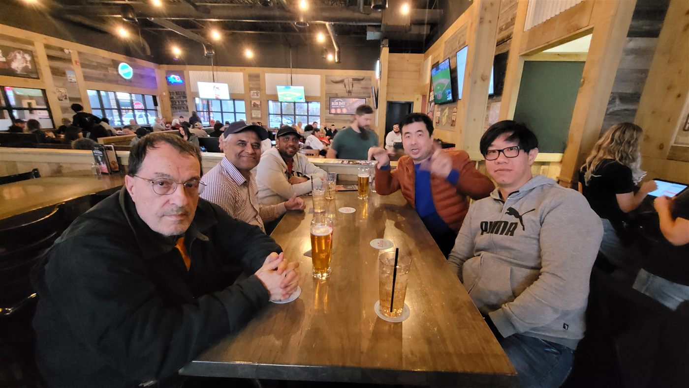 Calvin sharing a meal and drinks with a small group of friends